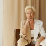 Portrait of a confident businesswoman in a stylish suit, smiling and posing indoors.